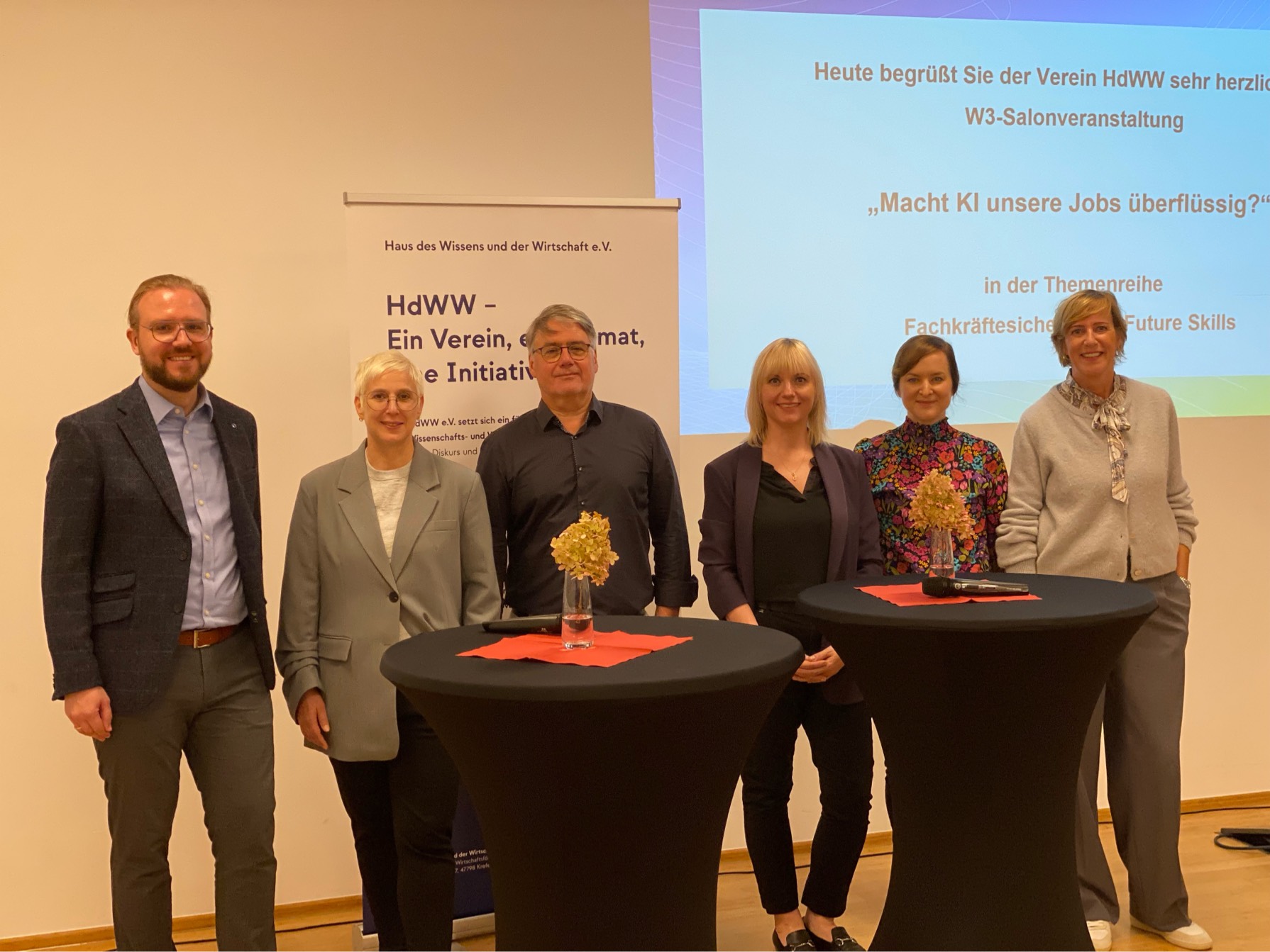 HdWW-Themenpatin Kerstin Abraham (r.) konnte zahlreiche Gäste begrüßen. Die Expertinnen und Experten des Vormittags waren (v.l.) Prof. Dr. Hendrik Poschmann (Hochschule Niederhein), Sandra Hackländer (Currenta), Dr. Frank Bauer (IAB Institut für Arbeitsmarkt- und Berufsforschung), Mirjam Crespin (Schwarz Produktion) und Prof. Dr. Frauke Austermann (Hochschule Niederrhein). Foto: HdWW